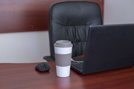 Wood office desk table with laptop, cup of coffeeの写真素材