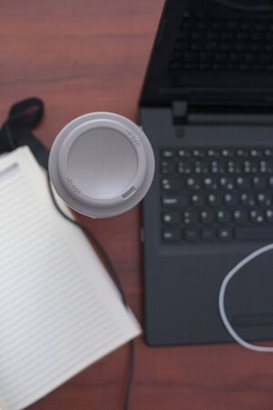 Wood office desk table with laptop, cup of coffeeの写真素材