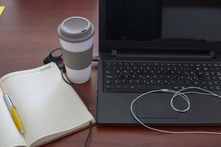 Wood office desk table with laptop, cup of coffeeの写真素材