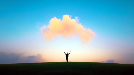 Silhouette of a figure with arms raised facing a pastel sky with a peach-colored cloud above a hill.の写真素材