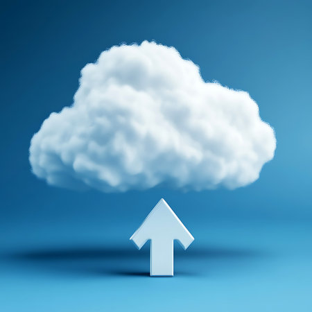 A fluffy cloud hovers above a white upward-pointing arrow on a simple blue background suggesting uploads.の写真素材