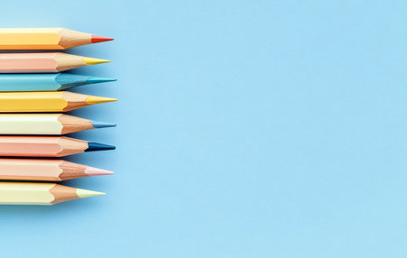 A vibrant collection of colored pencils arranged on a soothing light blue backdrop.の写真素材