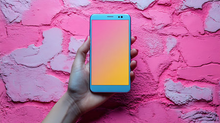 female hand holding smartphone with blank screen on pink wall background, mockupの写真素材