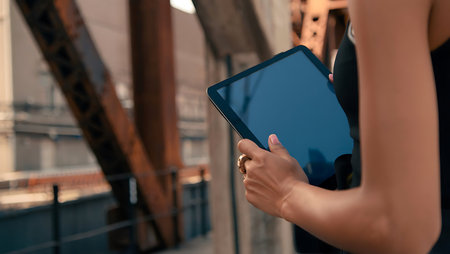 Close-up of a young woman using a digital tablet in the city