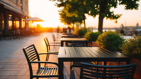 Tables and chairs in a cafe on the background of the sunsetの写真素材