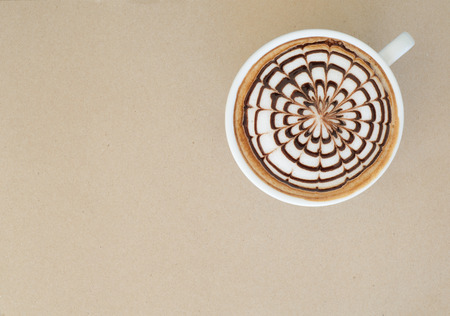 a cup of latte art on brown paper backgroundの写真素材