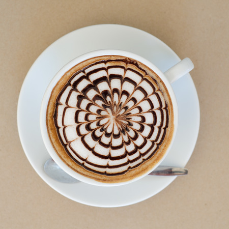 a cup of latte art on brown paper backgroundの写真素材