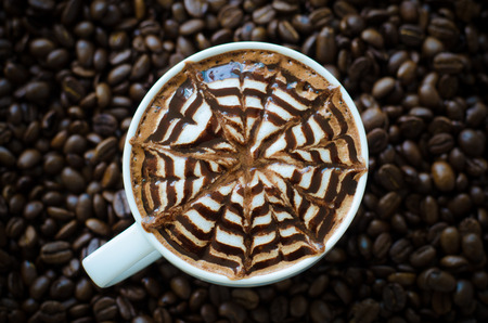 a cup of latte art on coffee bean backgroundの写真素材