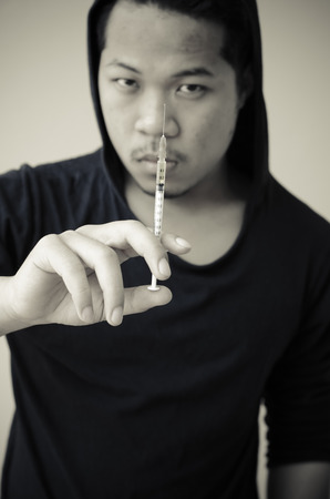 drug addict man with syringe in handの写真素材