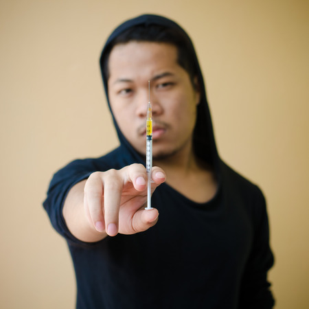 drug addict man with syringe in handの写真素材