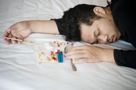 drug addict laying on the bedの写真素材