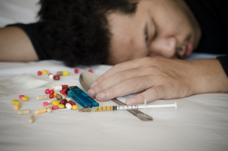 drug addict laying on the bedの写真素材