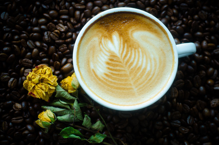 a cup of latte art on coffee bean backgroundの写真素材