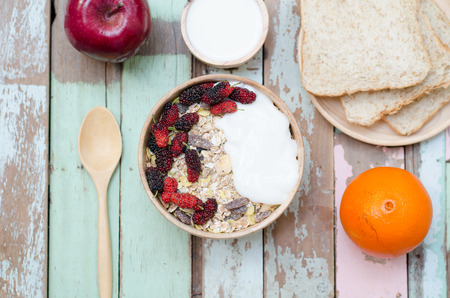 breakfast : home made yogurt with oat flakes  in bowl on wooden tableの写真素材