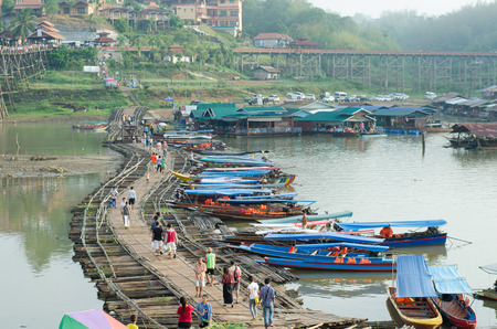 SANGKLABURI ,THAILAND - MAY 3, 2015 : Traveler crossing wooden bridge or Mon Bridge in Sangklaburi. Kanchanaburi, Thailand. Attractions traditional way of lifeのeditorial素材