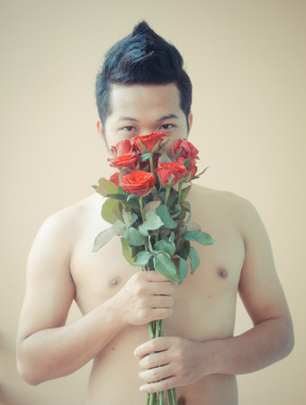 naked men holding a flowerの写真素材