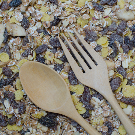 wooden fork and spoon on oat flakes background