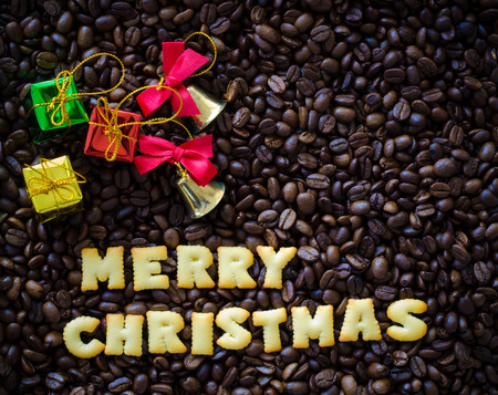 alphabet "merry christmas" made from bread cookies on coffee beans backgroundの写真素材