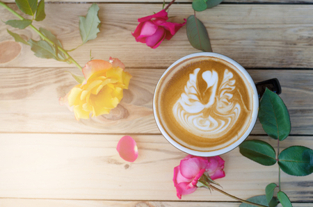 hot coffee with foam milk art on wooden tableの写真素材