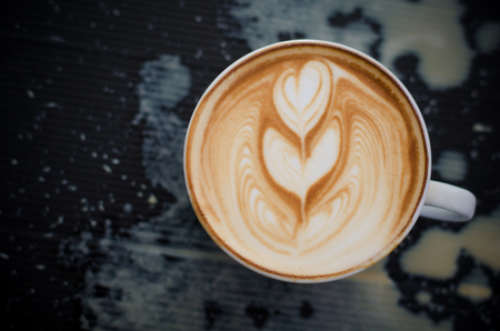 Latte art coffee spill on black backgroundの写真素材