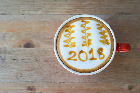 hot coffee with foam milk art 2018 on wooden table, latte art coffeeの写真素材