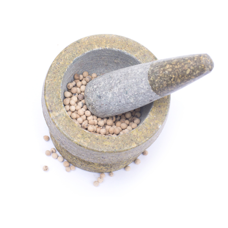 white  peppercorns in stone mortar isolated on white backgroundの写真素材