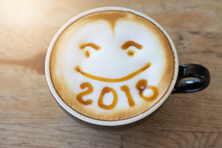 hot coffee with foam milk art 2018 on wooden table, latte art coffeeの写真素材