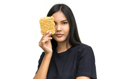 Young asian woman holding instant noodles isolated on white background. Unhealthy conceptの写真素材