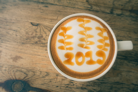 hot coffee with foam milk art 2019 on wooden table, latte art coffeeの写真素材