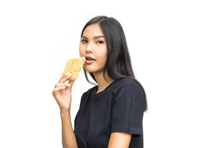 Young asian woman holding instant noodles isolated on white background. Unhealthy conceptの写真素材