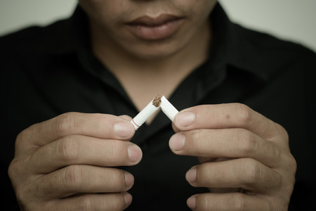 close up of man breaking the cigarette with handsの写真素材