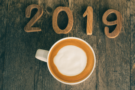 hot coffee with foam milk art 2019 on wooden table, latte art coffeeの写真素材