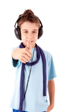 Cute little boy enjoying music using headphones and showing thumbs up over white backgroundの写真素材