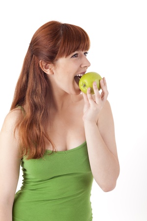 Beautiful young woman eating apple on white backgroundの写真素材