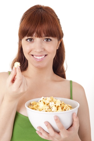 Beautiful woman eating popcorn on white backgroundの写真素材