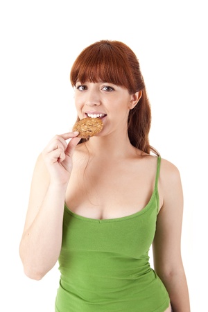 Beautiful young woman eating diet biscuits on white backgroundの写真素材