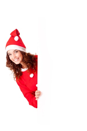 Beautiful smiling young christmas woman leaning on blank signの写真素材