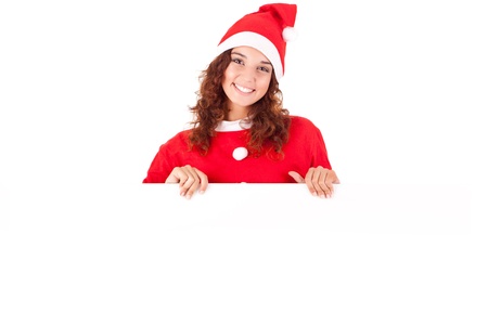 Beautiful smiling young christmas woman leaning on blank signの写真素材