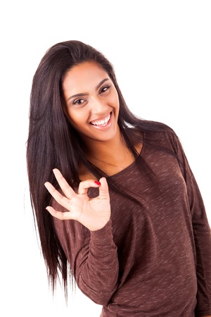 Beautiful mix race woman showing Ok sign over white backgroundの写真素材