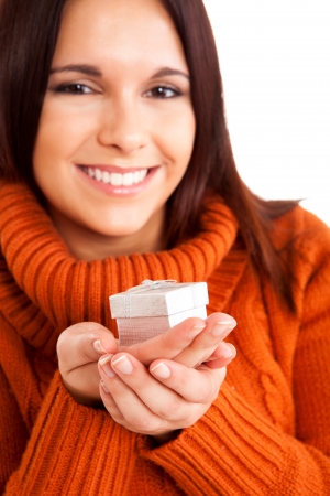 Beautiful woman holding a gift over white backgroundの写真素材