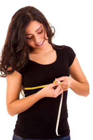 Beautiful slim woman measuring her body with a measuring tapeの写真素材