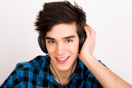 Young man listening music with headphones at homeの写真素材