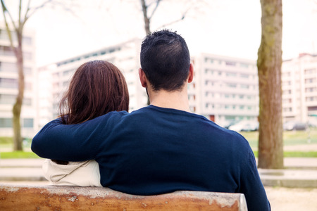Young romantic couple on a bench in parkの写真素材