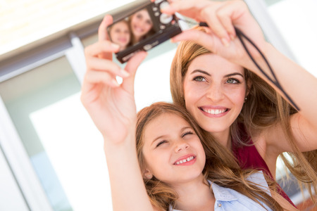 Girl taking a selfie with her mother or sisterの写真素材