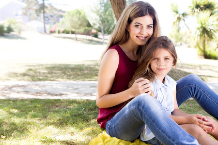 Mother and daughter relaxing in the city parkの写真素材