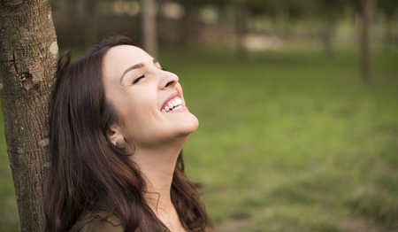 Woman with happy expression relaxing on meadowの写真素材