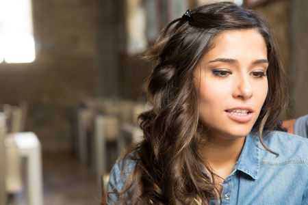 Portrait of a young woman sitting at cafe tableの写真素材
