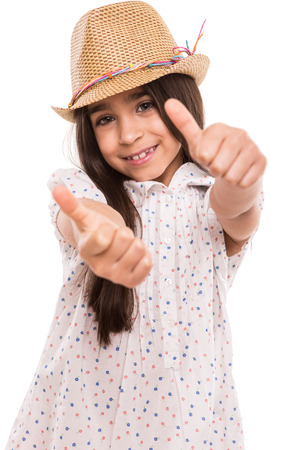 Little girl doing thumbs up over whiteの写真素材