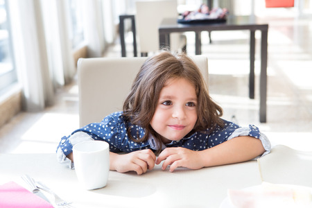 Little cute child having a tasty breakfastの写真素材
