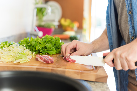 Detail of man in kitchen cooking healthy lunchの写真素材